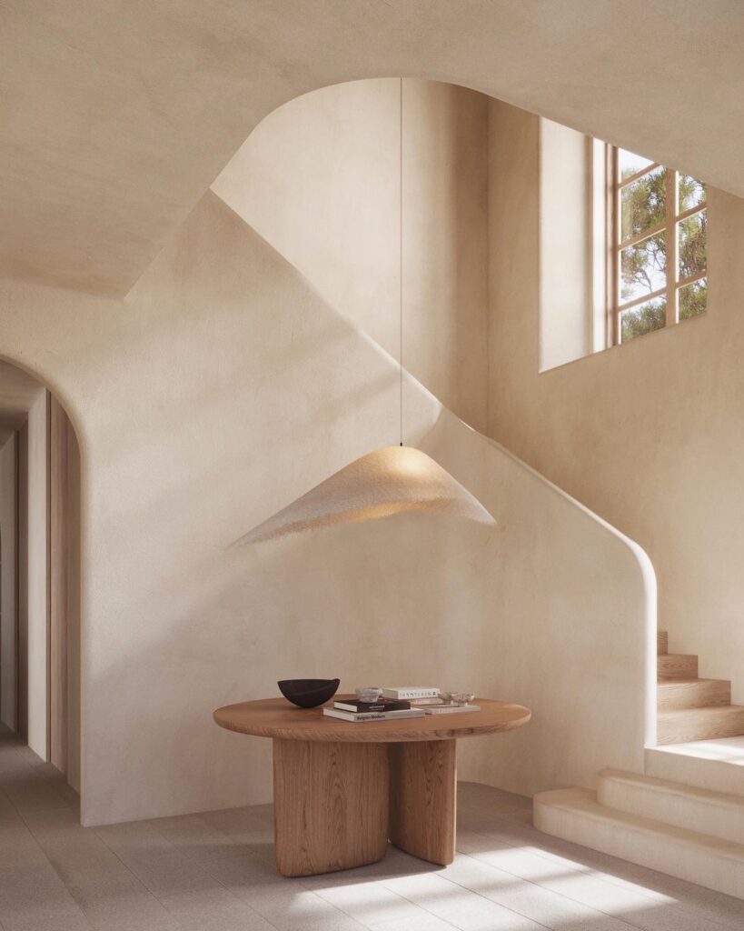 A view of an entrance hall with an architectural staircase and a modern central table with a natural ceiling lamp.